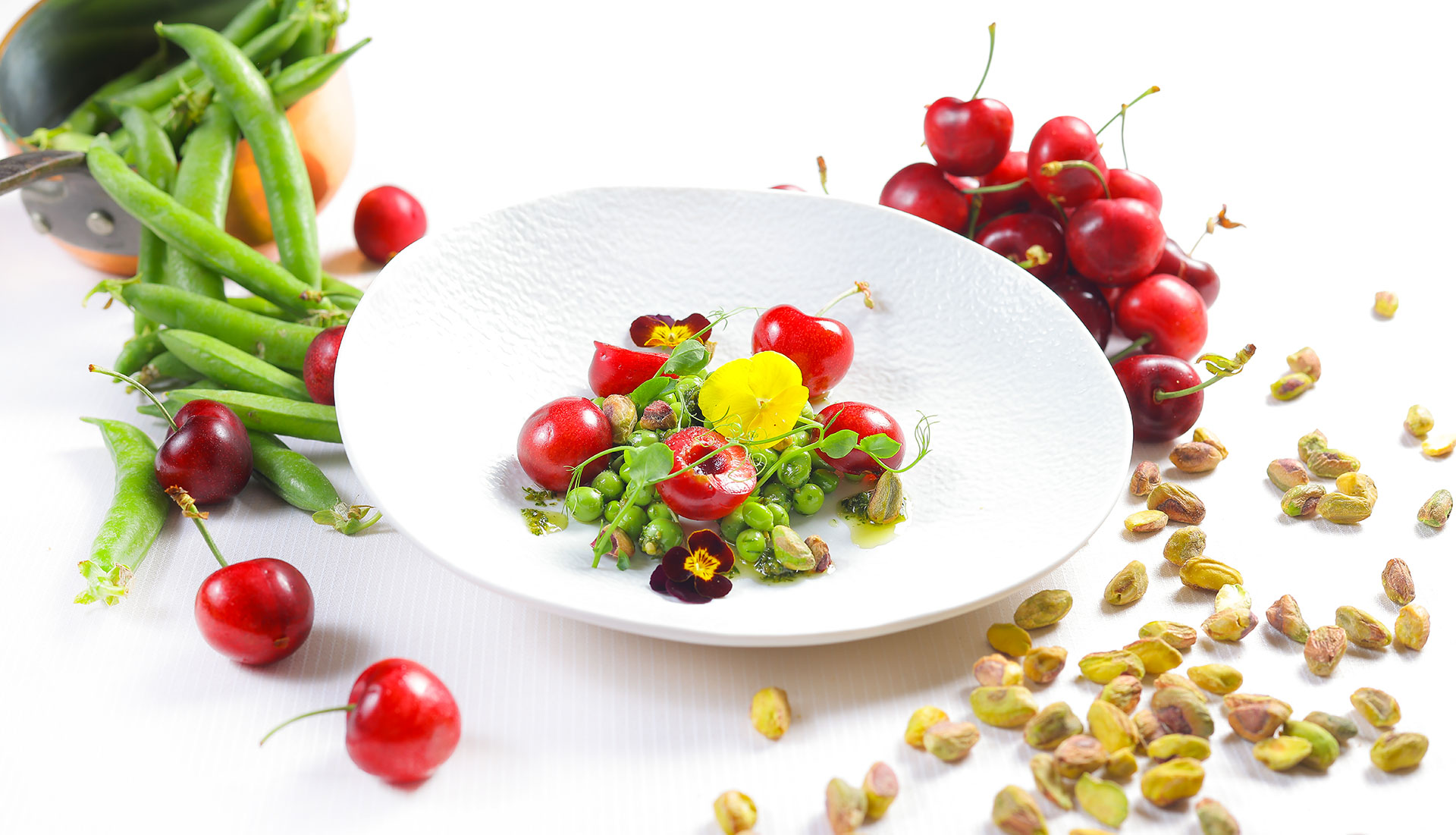 Assiette fraîcheur petits pois, cerises et pistaches, cuisine créative de saison