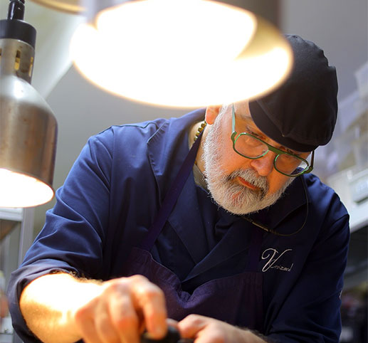Le chef Vincent Croizard en veste de cuisine signée, préparation minutieuse d'un plat