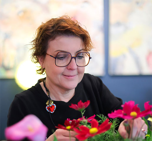 Madame Croizard composant un dressage floral avec des fleurs de cosmos, restaurant Vincent Croizard à Nîmes